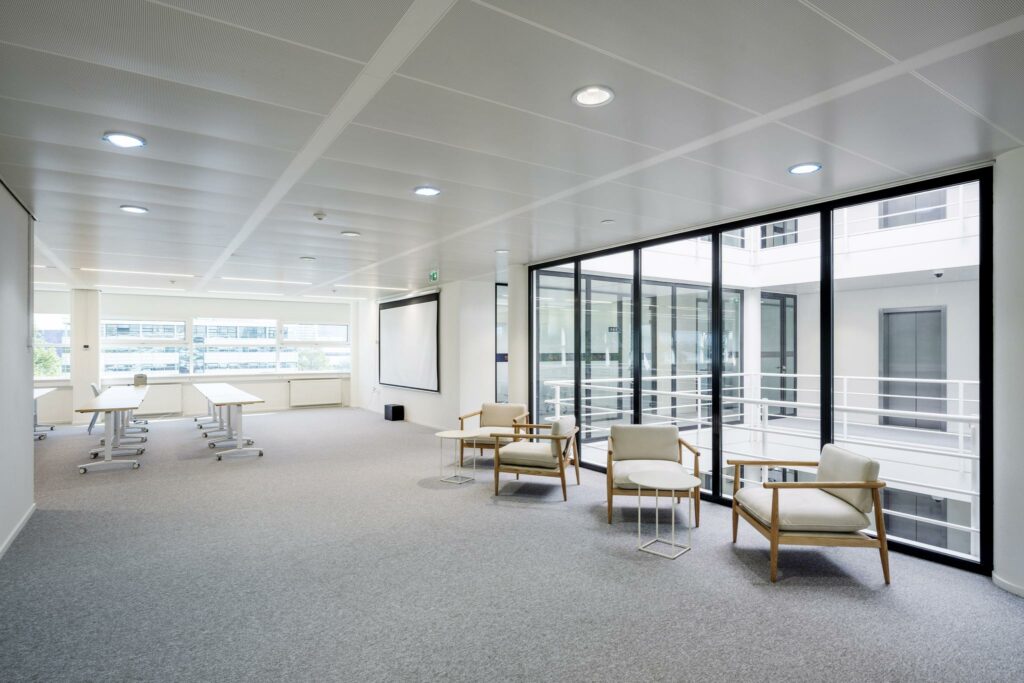 Moderne, lichte kantoorruimte aan de Burgemeester Stramanweg met flexibele werkplekken, zithoek en grote ramen.